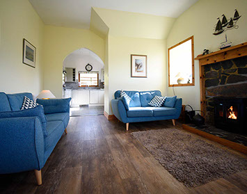 Auld Mission Cottage living room contains a woodburning stove and Smart TV