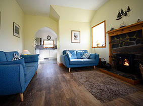 Auld Mission Cottage living room contains a woodburning stove and Smart TV