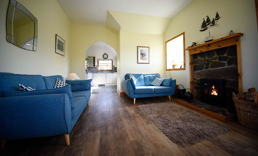 Auld Mission Cottage living room contains a woodburning stove and Smart TV